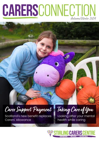 Smiling girl holding a large purple unicorn plush and pumpkins, seated outdoors on white chairs.