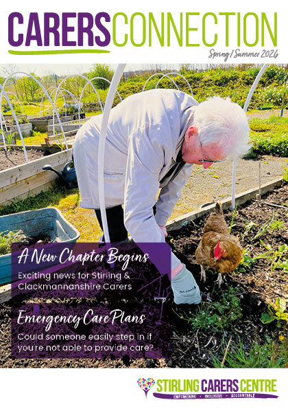 An elderly man is feeding a brown hen in a garden, shown on the cover of Carers Connection magazine.